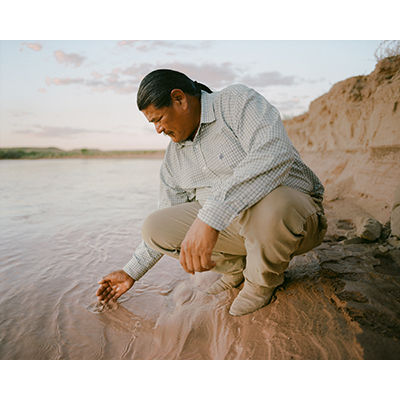 Nolan Stevens dips his hand into the Little Colorado River &copy; Elliot Ross
